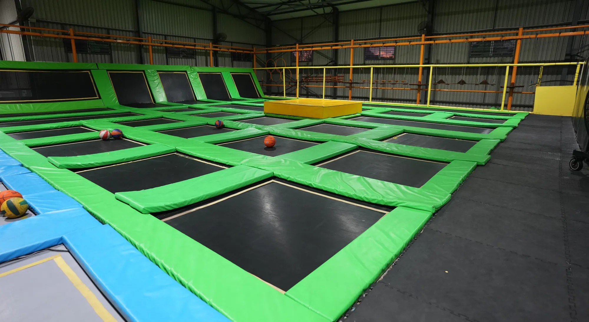 Green padded trampolines and a yellow platform at Jump Trampoline Park, Harare